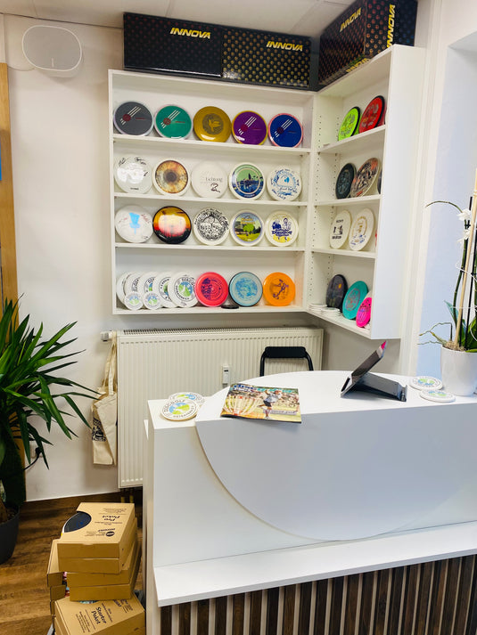 Kassenbereich im WOD Shop in Wenzenbach, mit Special Scheiben wie den Robinson Kyllini Beach Discs, Simon Lizotte Prototype Time Lapse und viele mehr